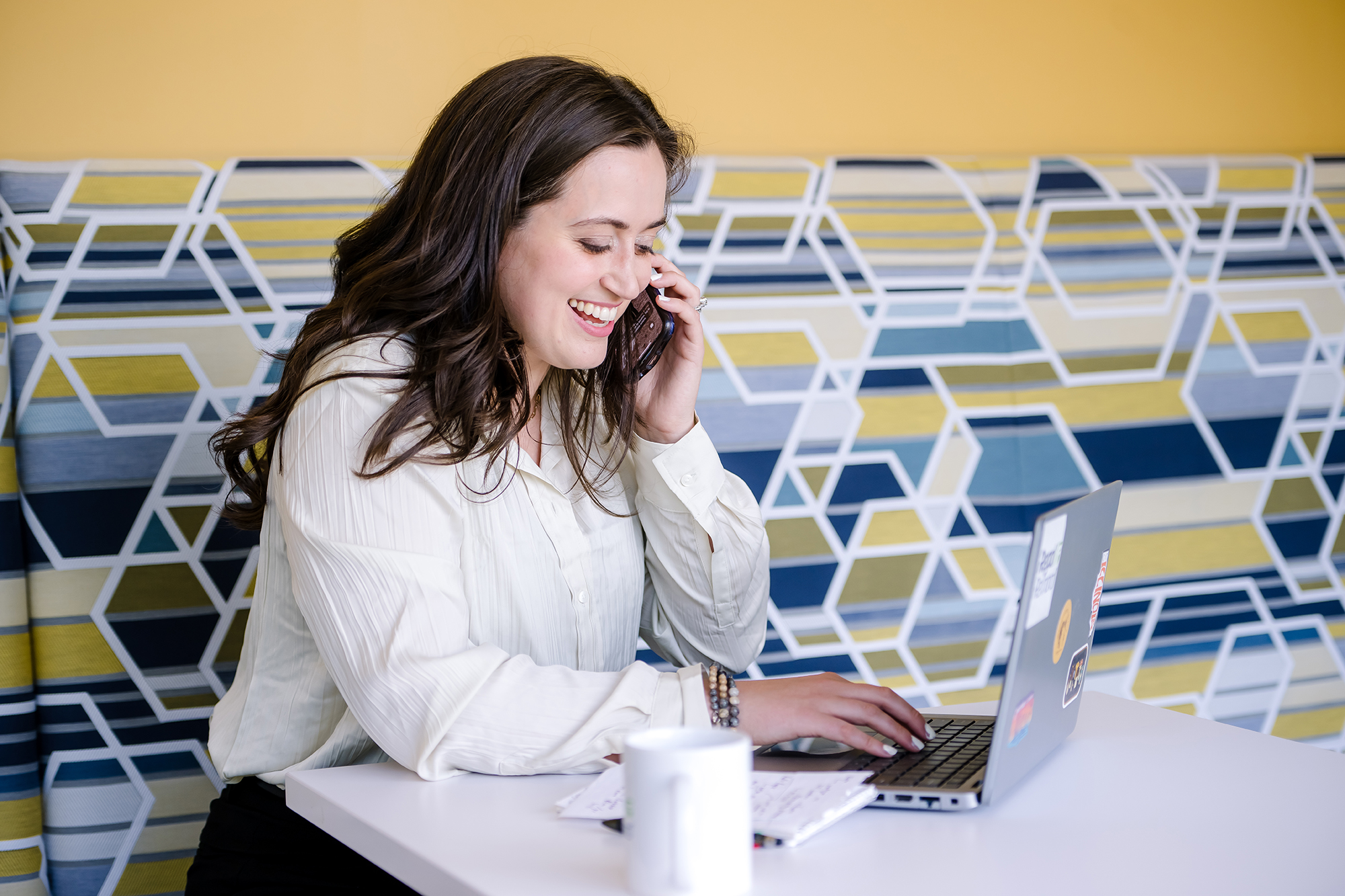 a person sitting at a desk talking on the phone