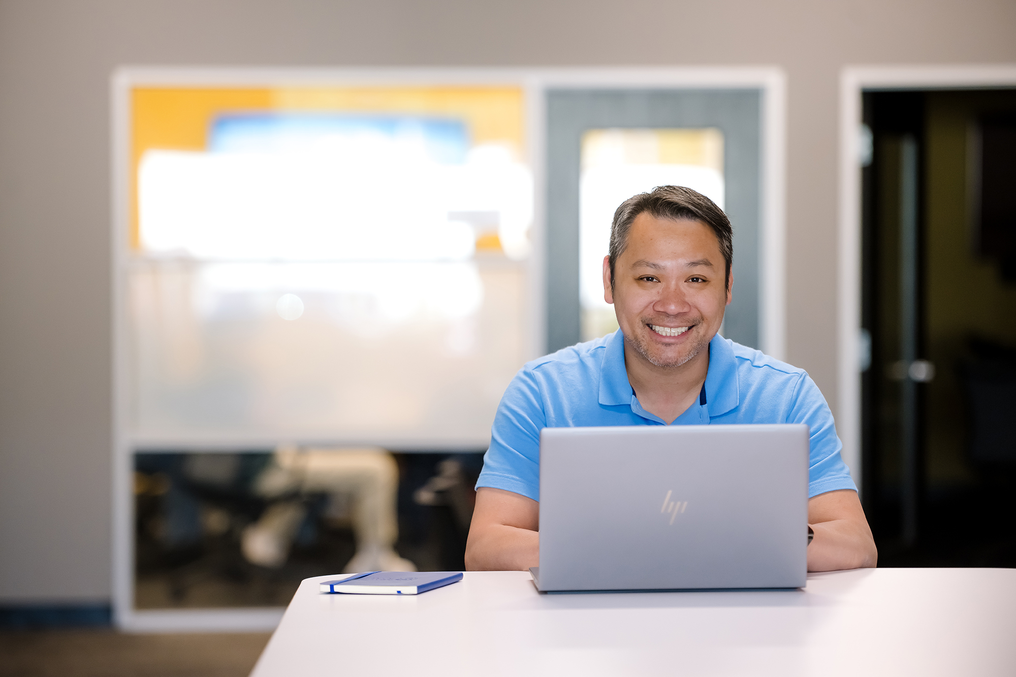 a person sitting at a table with a laptop