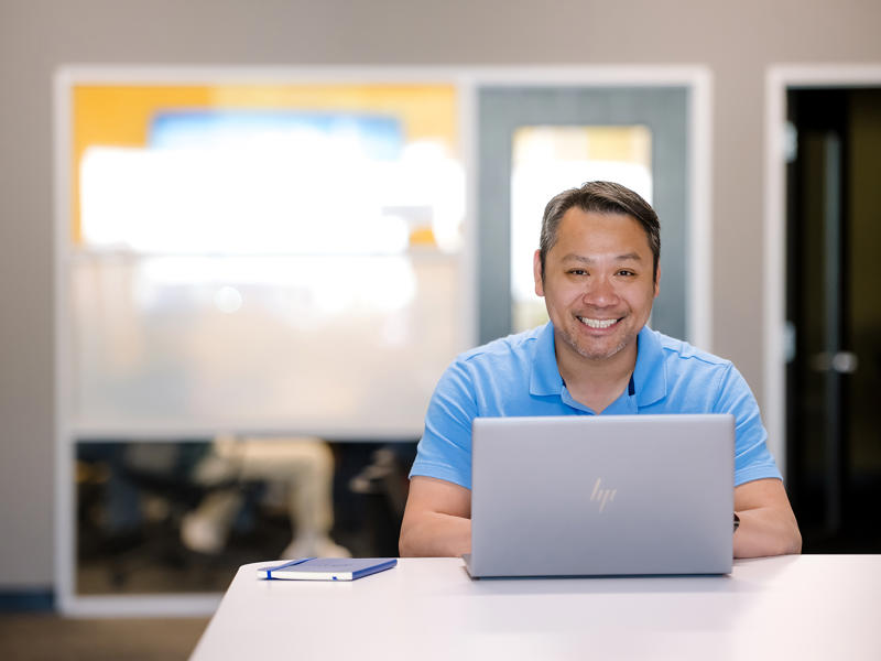 a person sitting at a table with a laptop