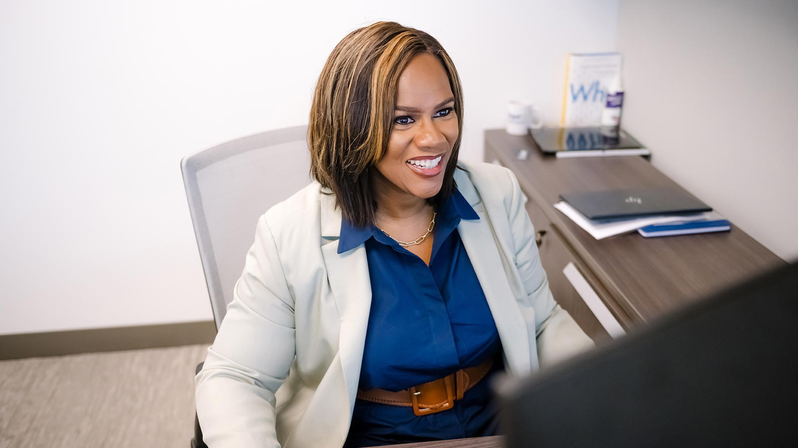 a person sitting at a desk smiling