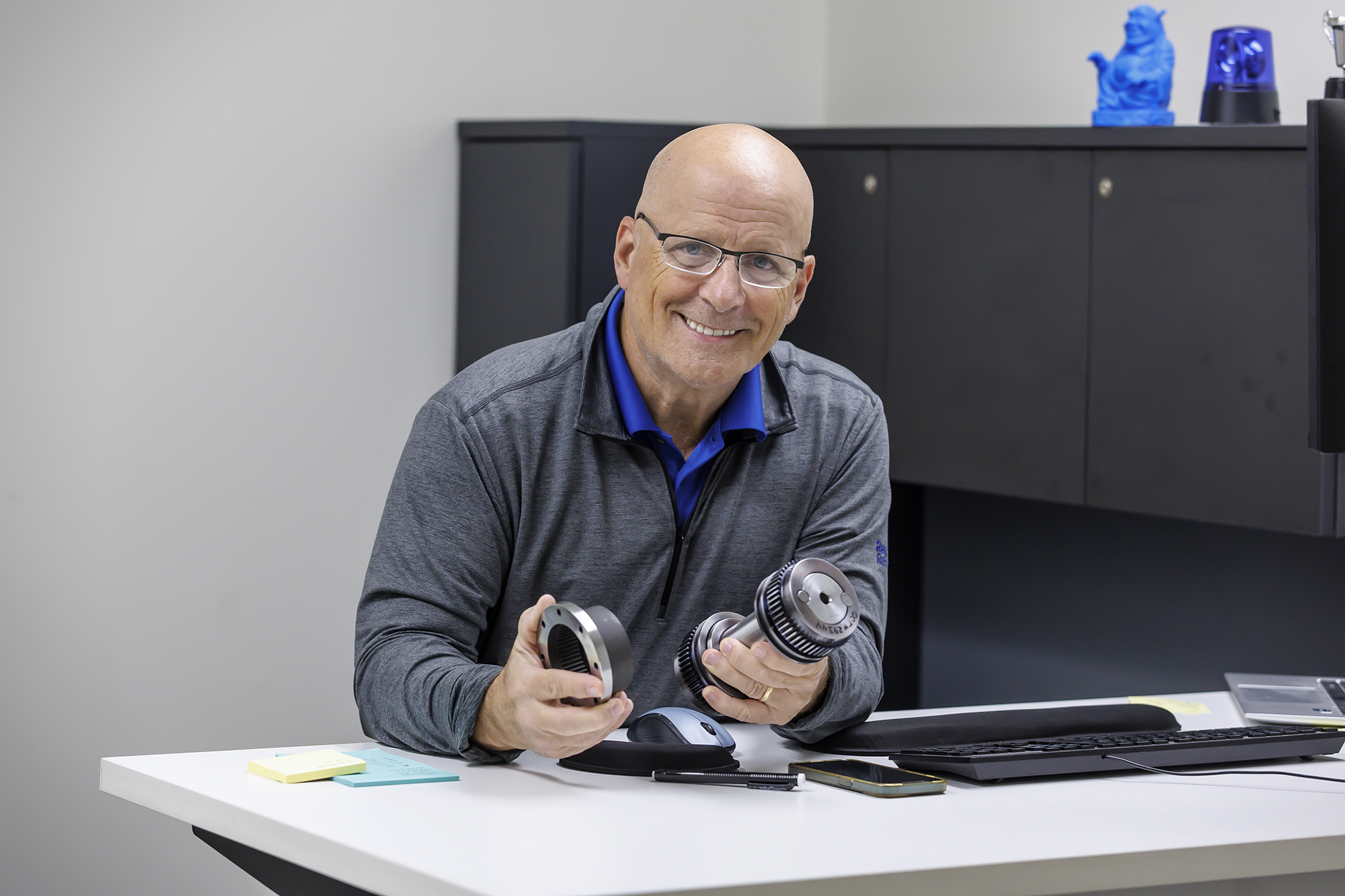 a person sitting at a desk holding a pair of objects