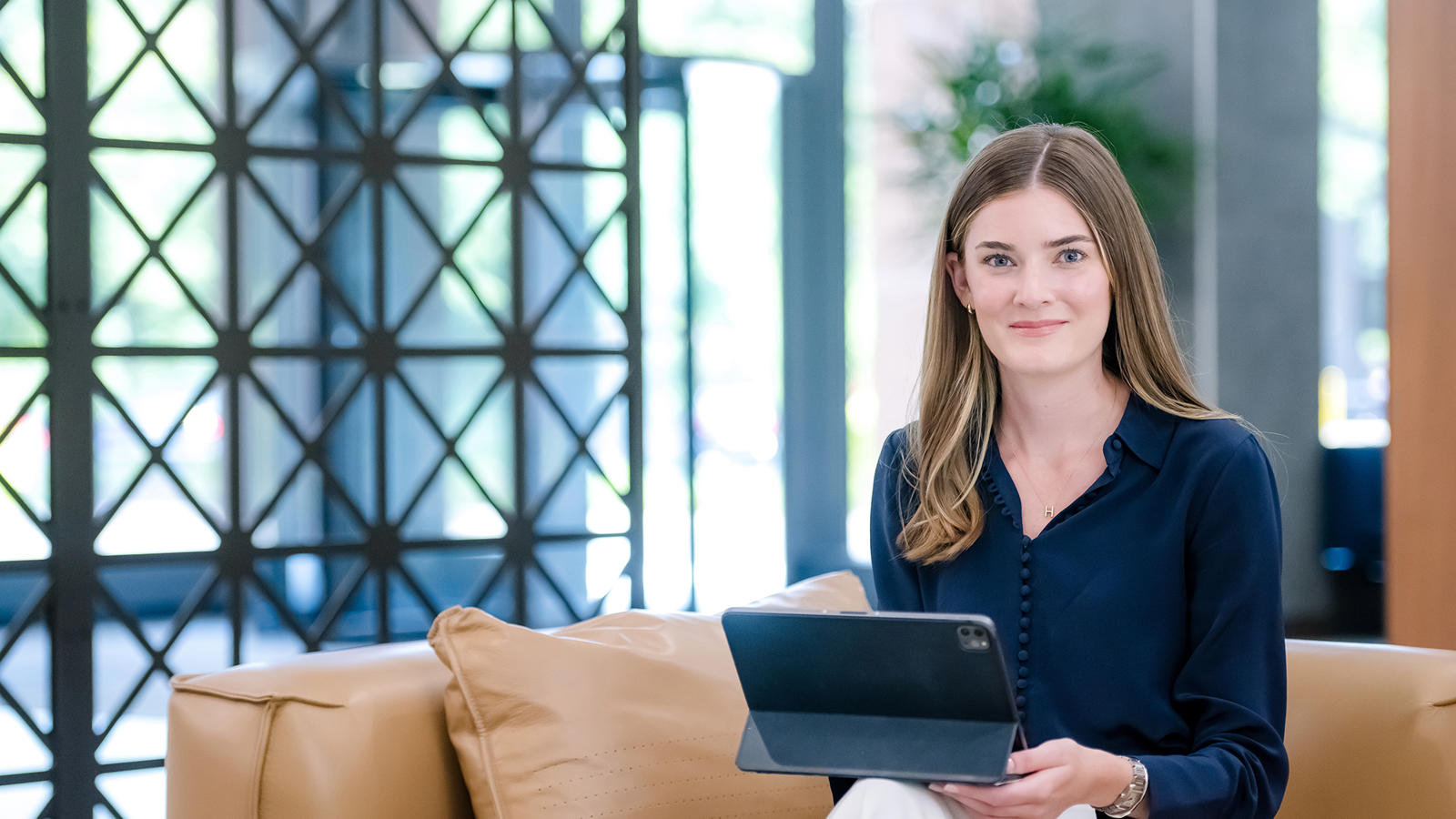 a person sitting on a couch holding a tablet