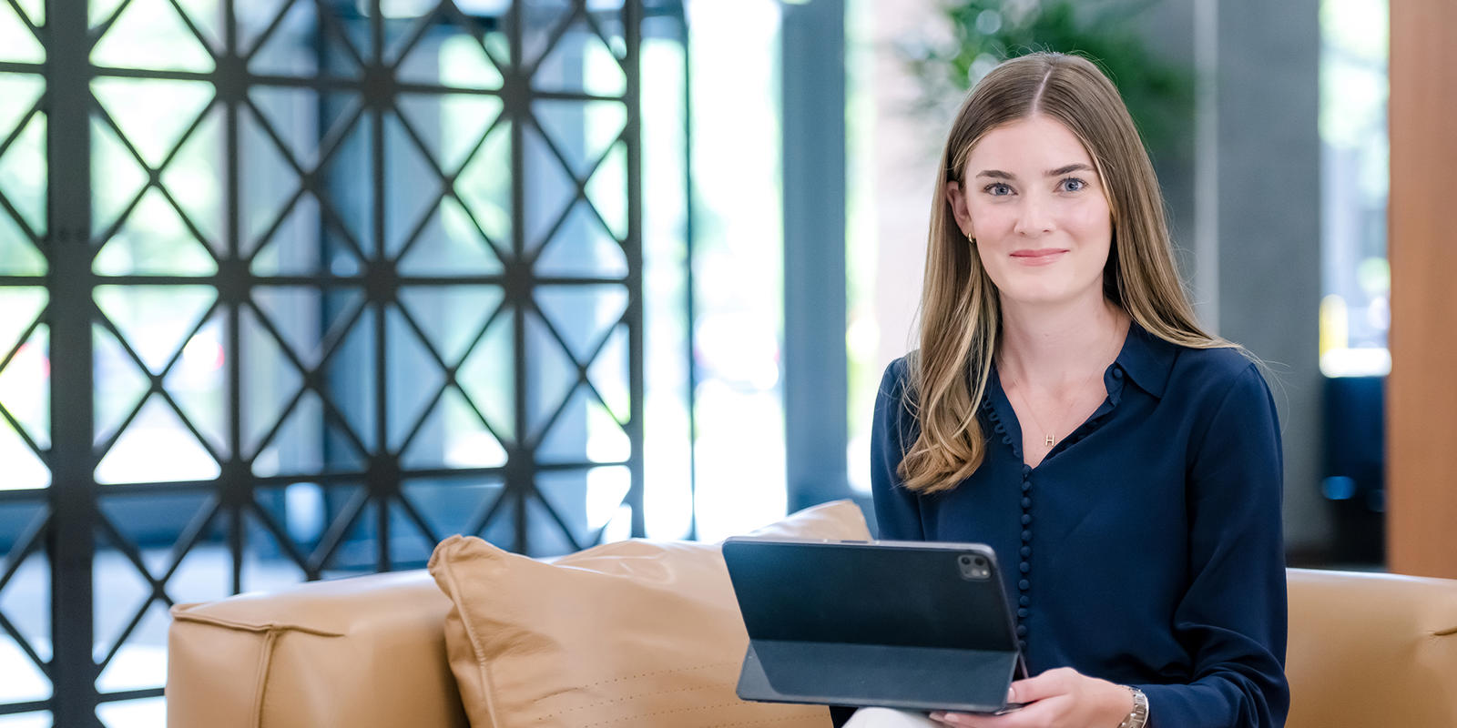 a person sitting on a couch holding a tablet