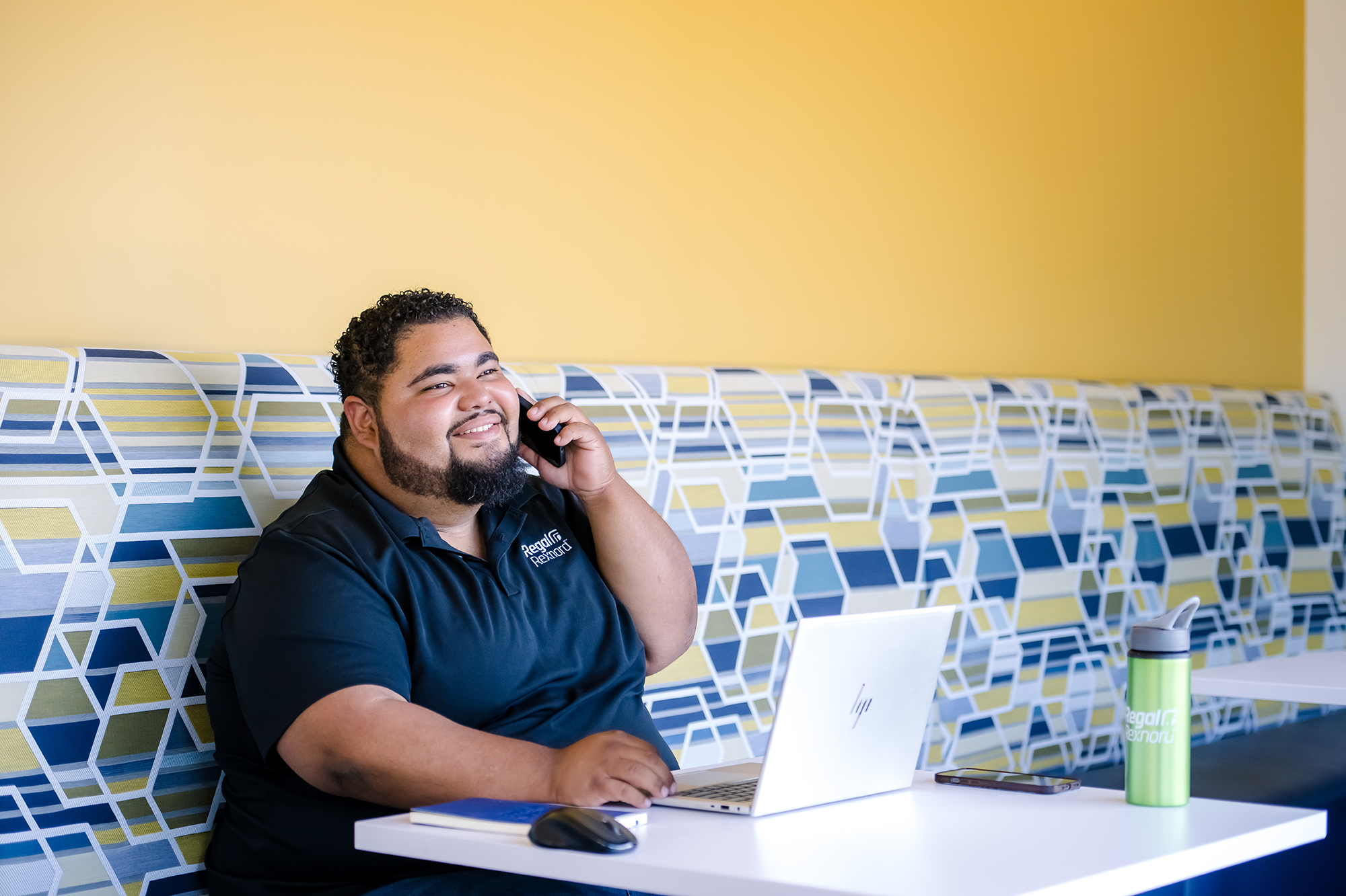 a person sitting at a table talking on a cell phone