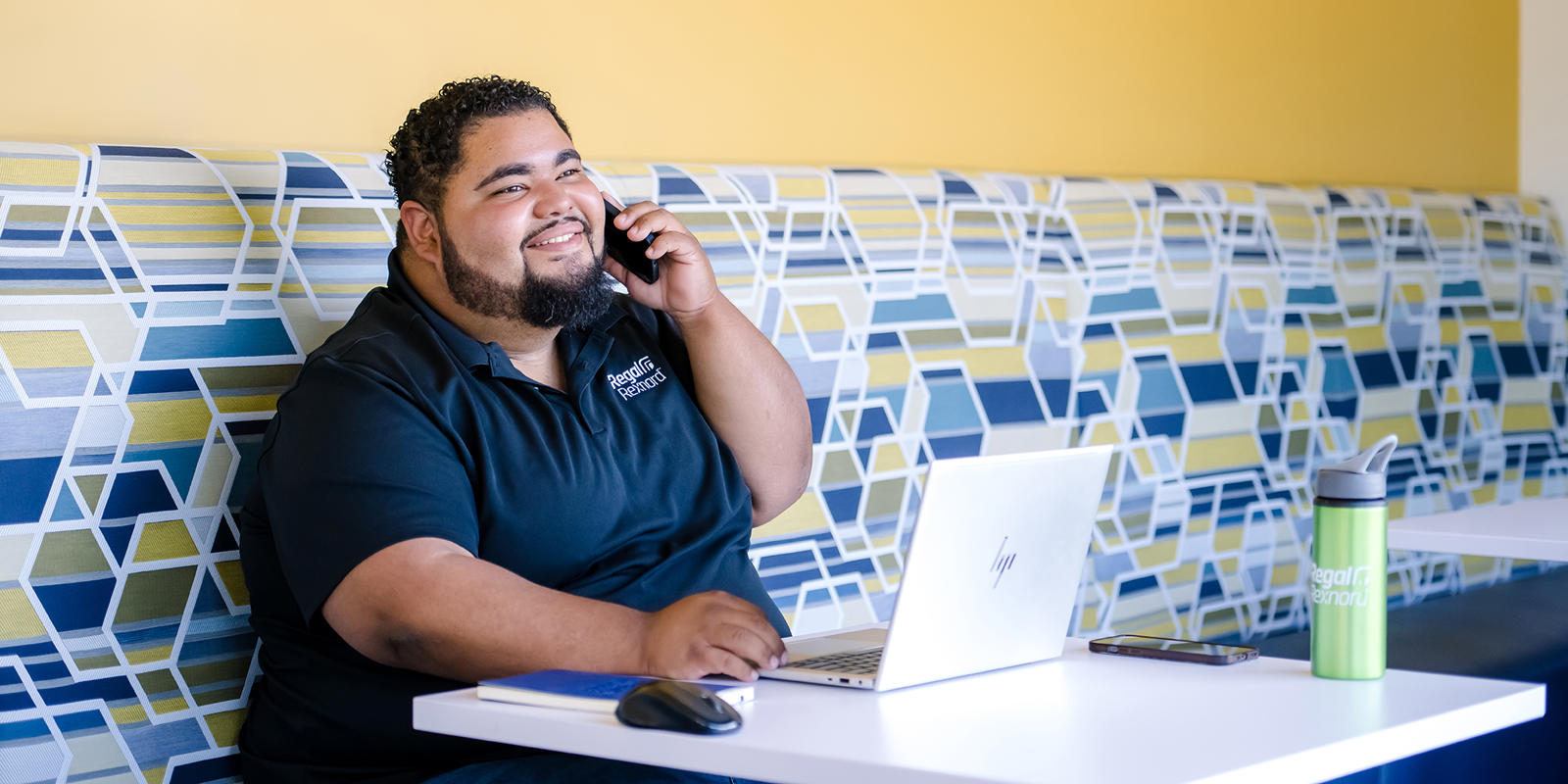 a person sitting at a table talking on a cell phone