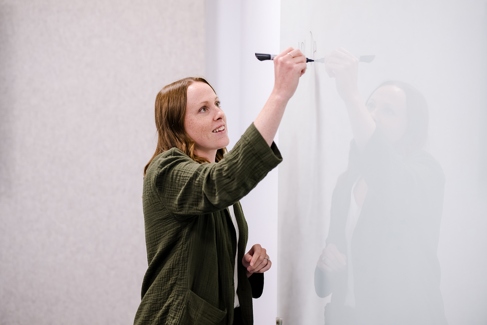 a person writing on a whiteboard