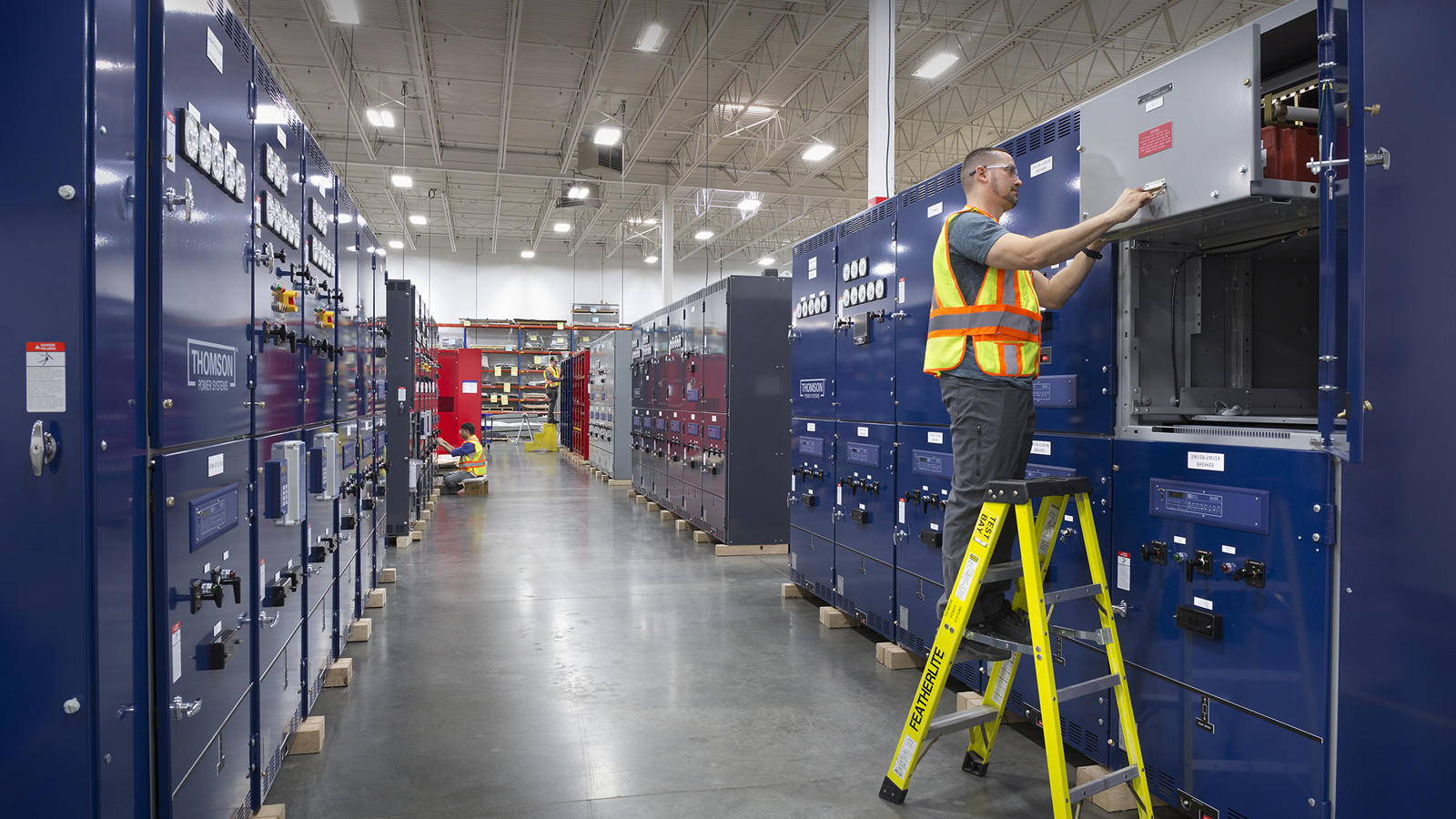 a person on a ladder in a factory