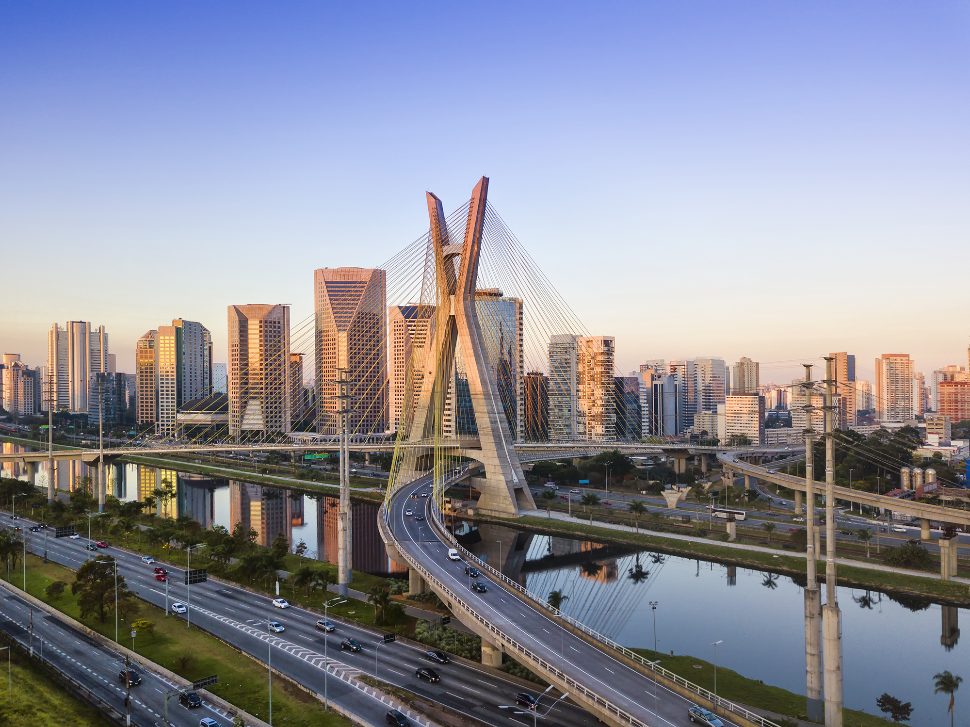 a bridge over a river with a city in the background