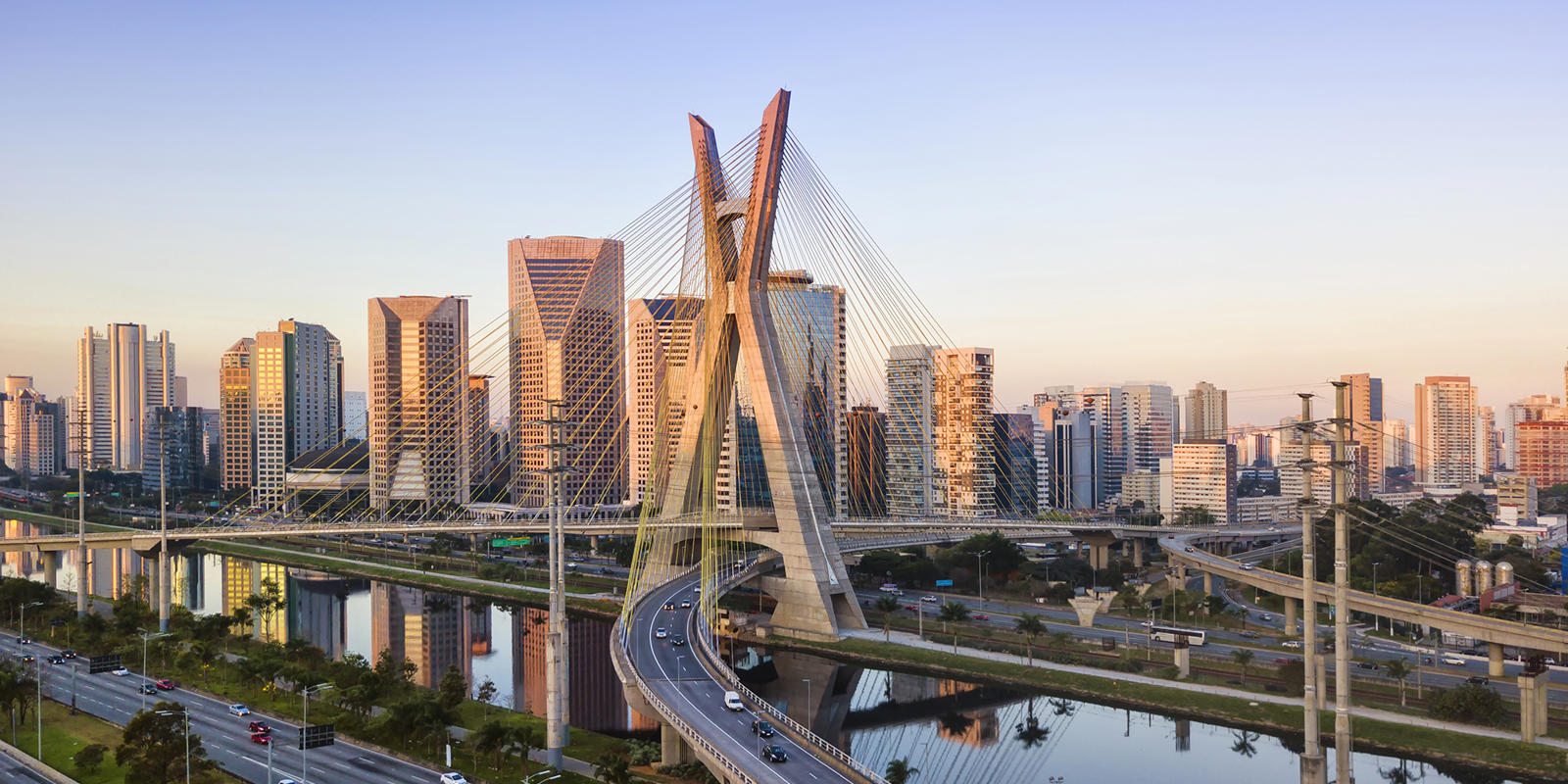 a bridge over a river with a city in the background
