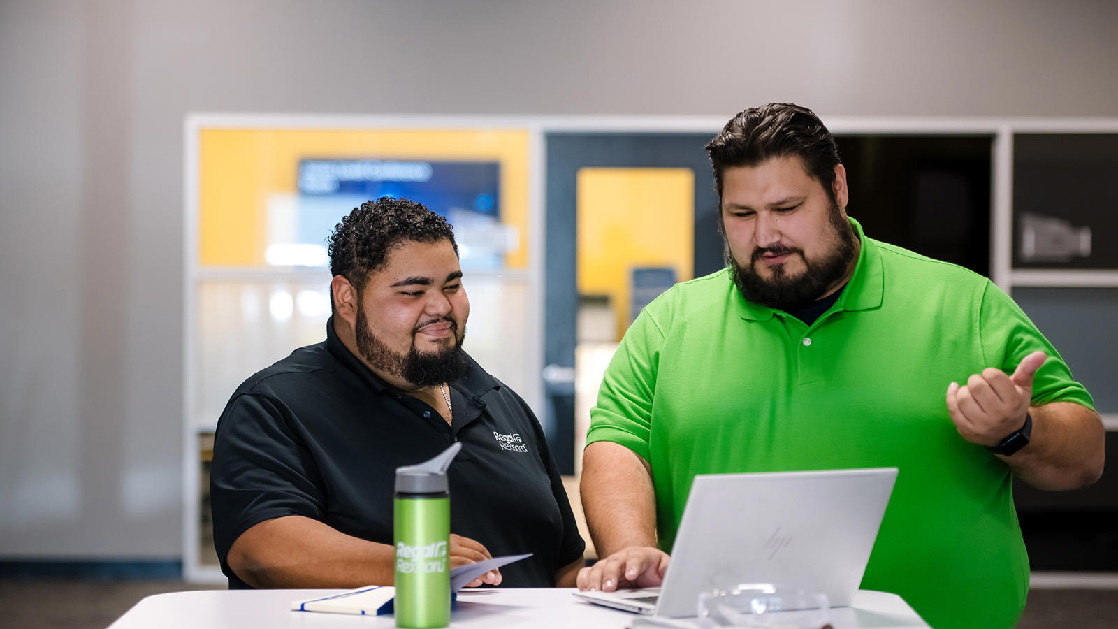 two men looking at a laptop
