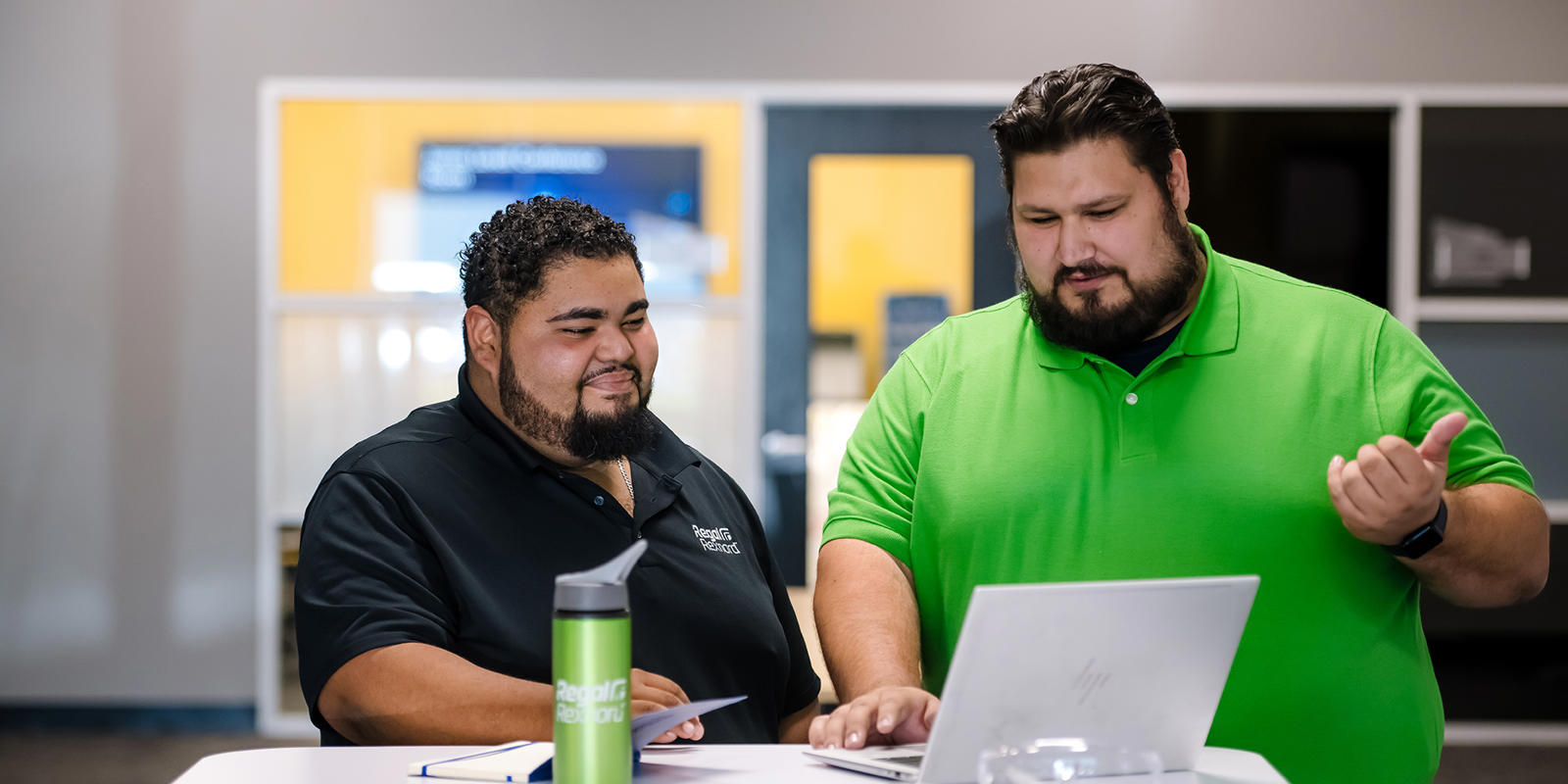 two men looking at a laptop